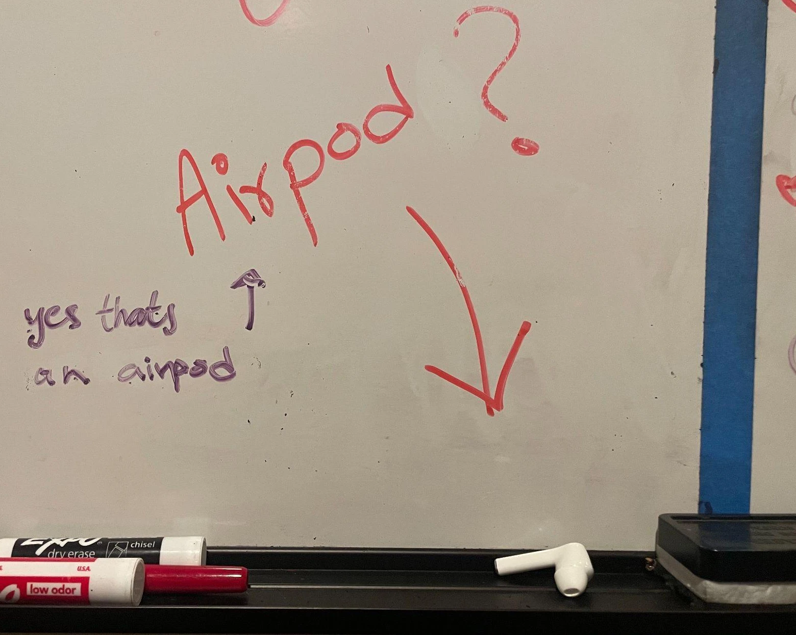 Whiteboard sketch with 'Airpod' written in red marker and an arrow pointing to a drawing.