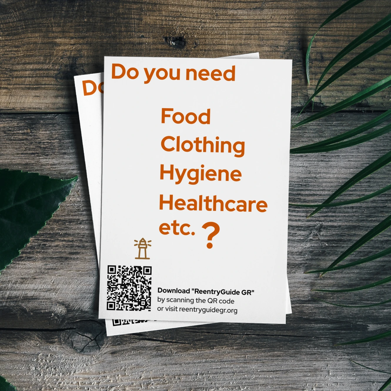 White flyer on wooden table with text 'Do you need Food, Clothing, Hygiene, Healthcare etc.?' and QR code